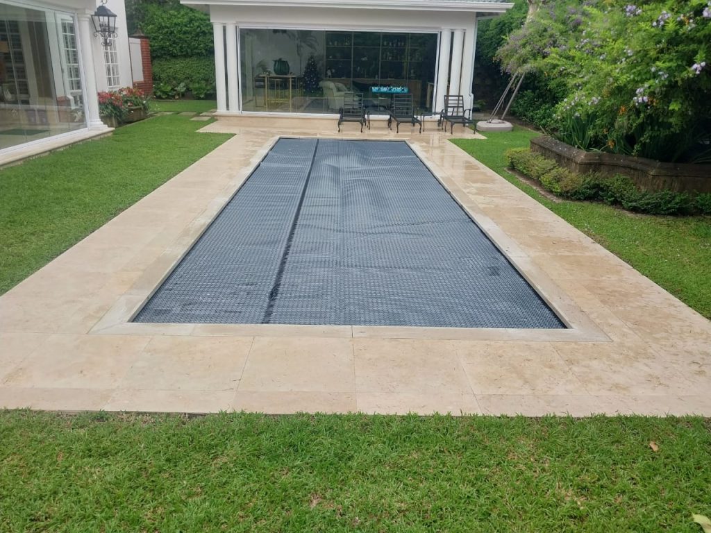designer pool covers A swimming pool with a black tarp covering it.