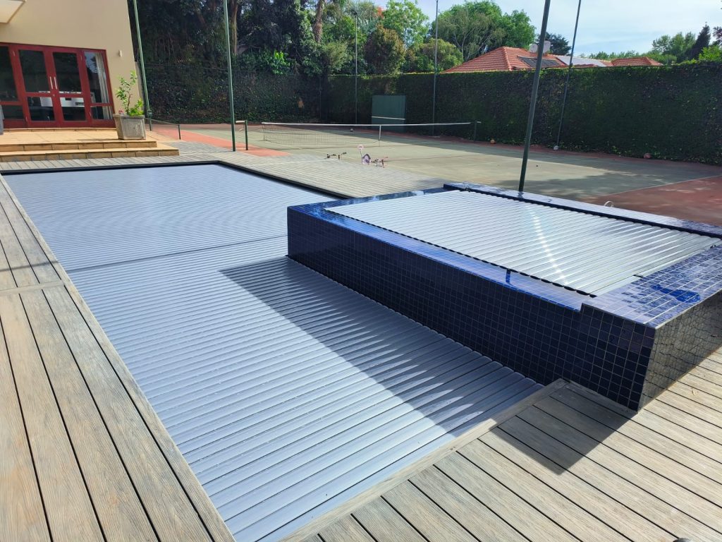 designer pool covers A wooden deck with a swimming pool and a tennis court.