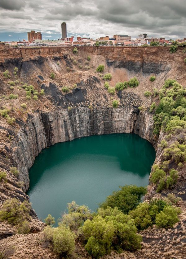 designer pool covers A large hole in the ground with a pool covers lake in the middle.